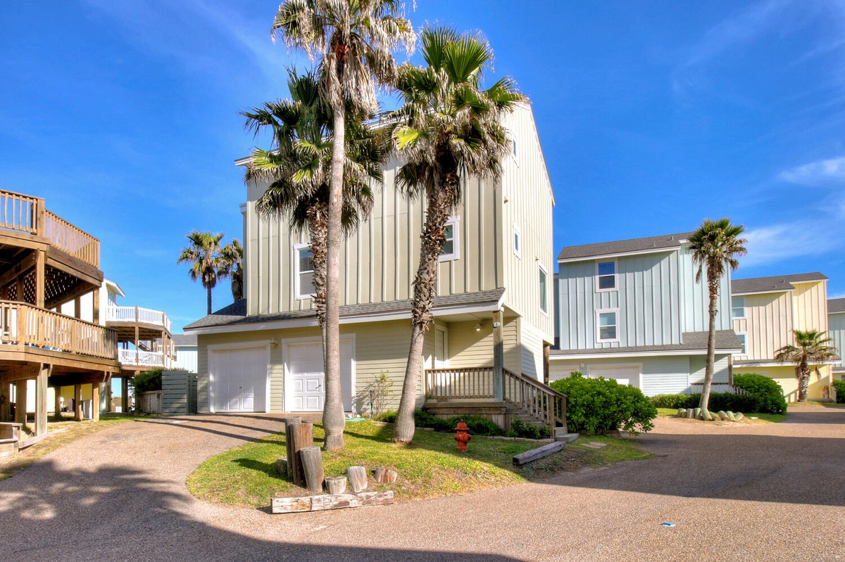 Modern beachside homes with palm trees create a relaxed coastal community setting for your vacation getaway.