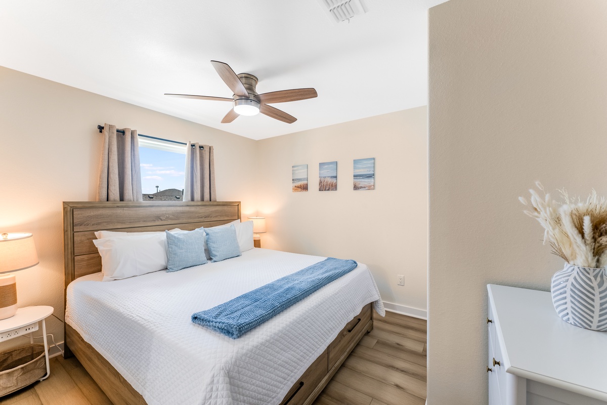 Drift off in your serene bedroom with coastal-inspired decor, soft linens, and gentle ceiling fan creating the perfect peaceful retreat.