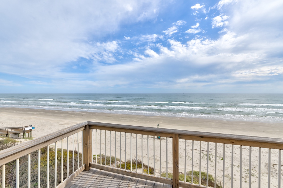 Oceanfront deck with unobstructed beach views and rolling waves stretching to the horizon.