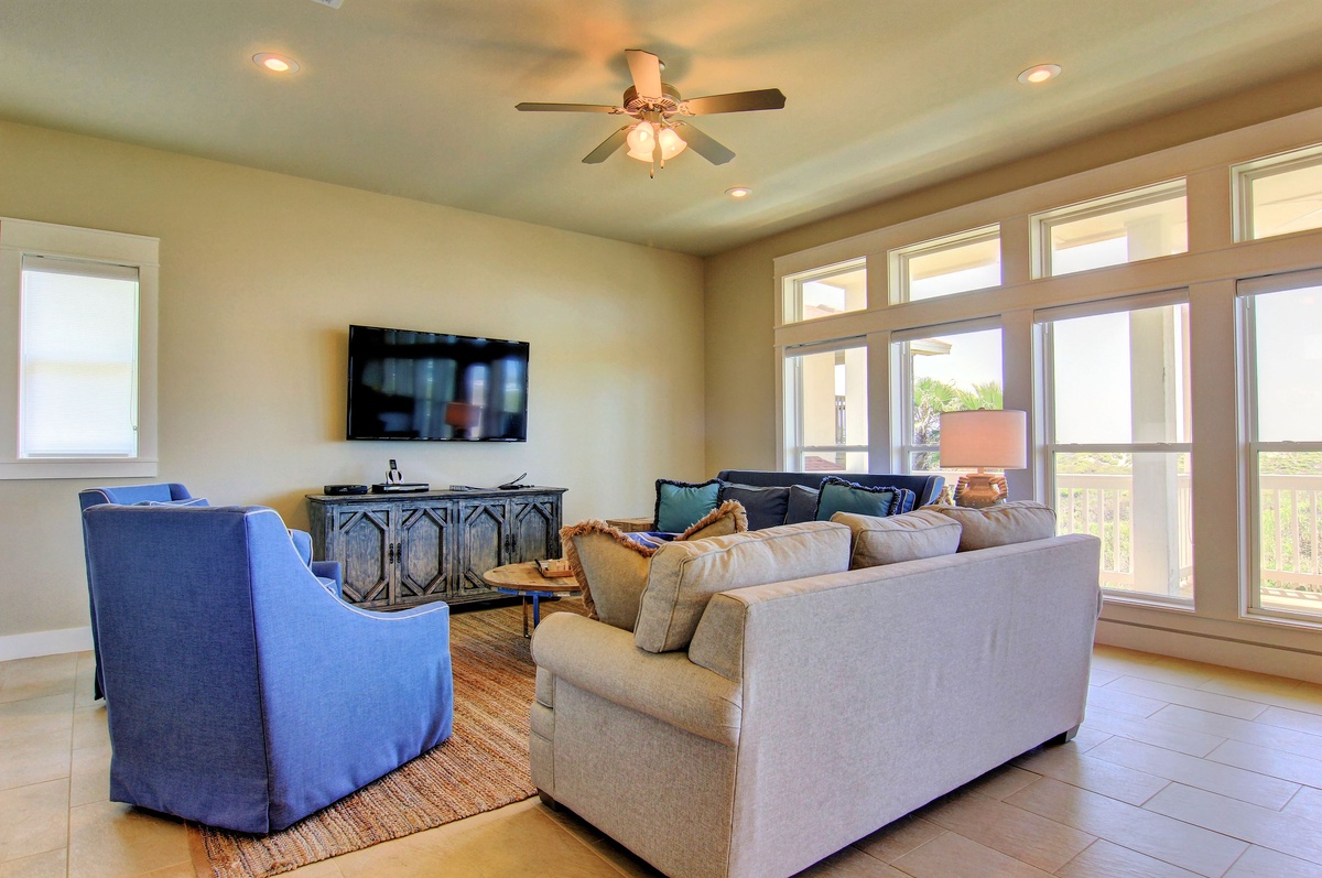 Unwind in your spacious living room with plush seating, entertainment center, and panoramic windows flooding the space with natural light.