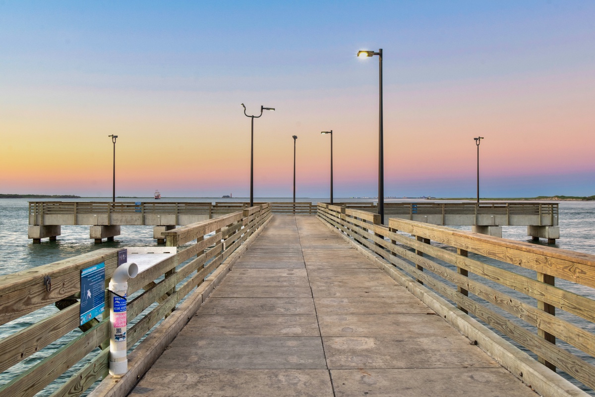 Cline's Landing fishing pier stretches into calm waters, perfect for sunset strolls and peaceful moments by the sea.