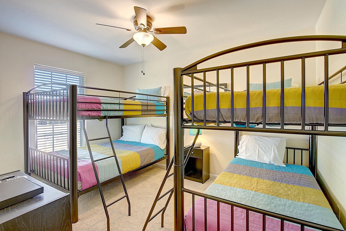 Your kids will love this cheerful bunk room! Colorful striped bedding and modern metal frames create the perfect space for family adventures.