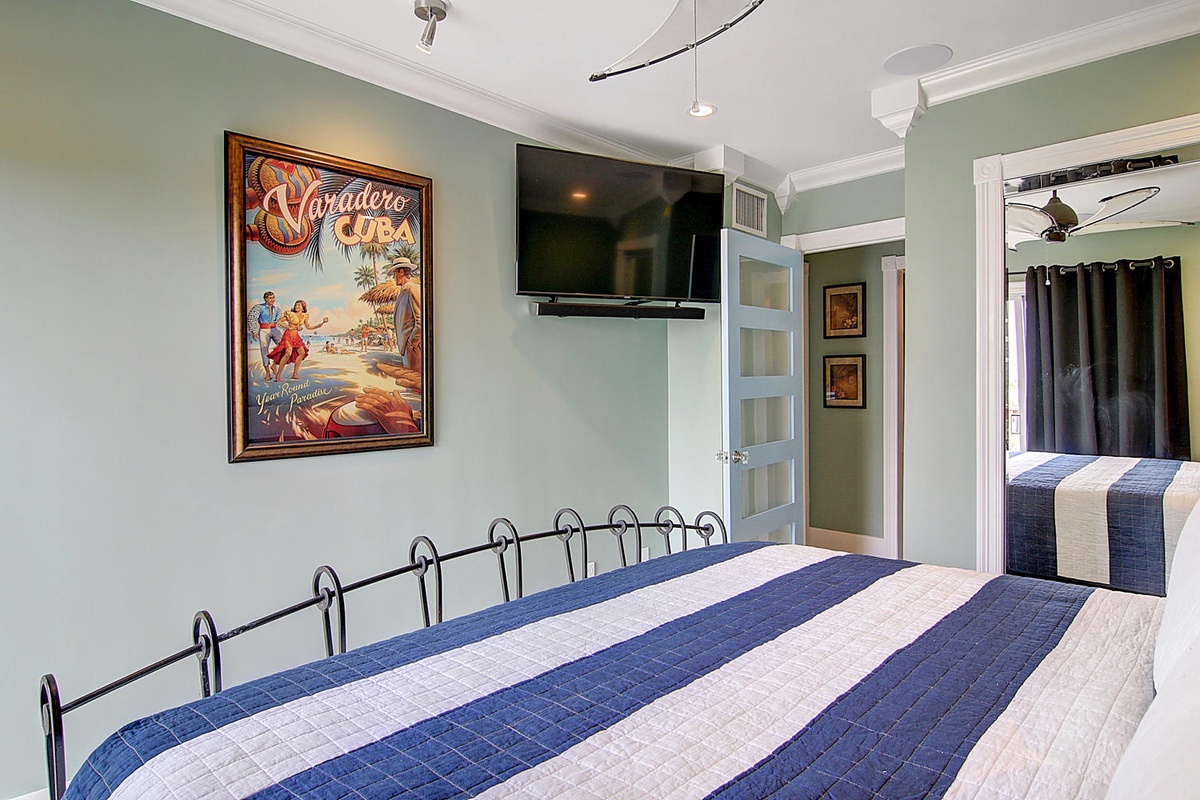 Unwind in your cozy bedroom with tropical Cuban flair, complete with a wall-mounted TV for lazy mornings and peaceful nights.