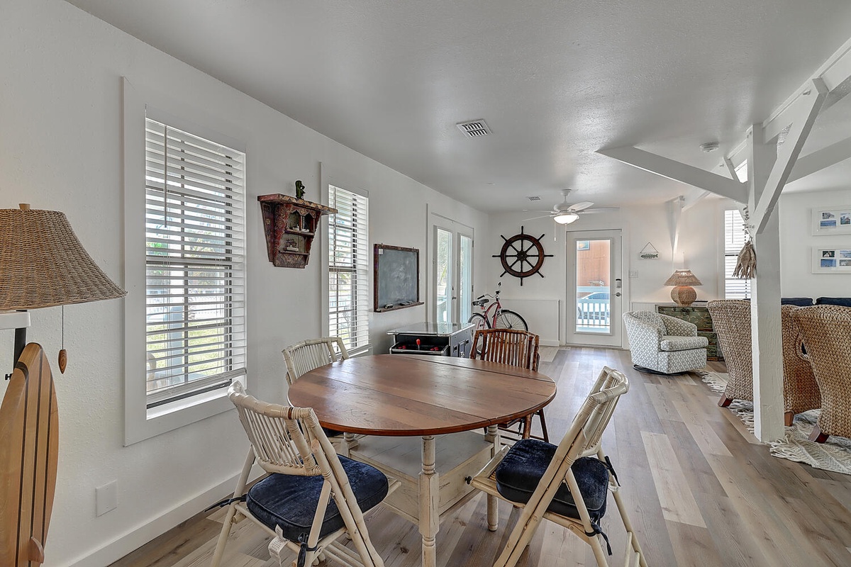 Gather around your nautical-themed dining table where coastal charm meets comfort. Natural light flows through plantation shutters as you plan your day.