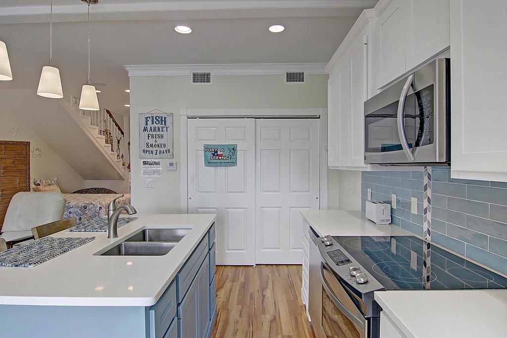 Cook in your modern galley kitchen with sleek quartz counters, stainless appliances, and coastal subway tile—perfect for preparing seaside meals.