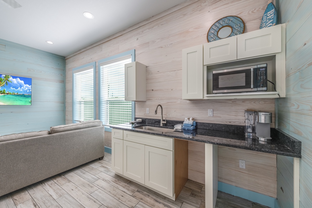 Your modern kitchenette features granite counters, stainless appliances, and coastal charm with soothing blue-green accents throughout.