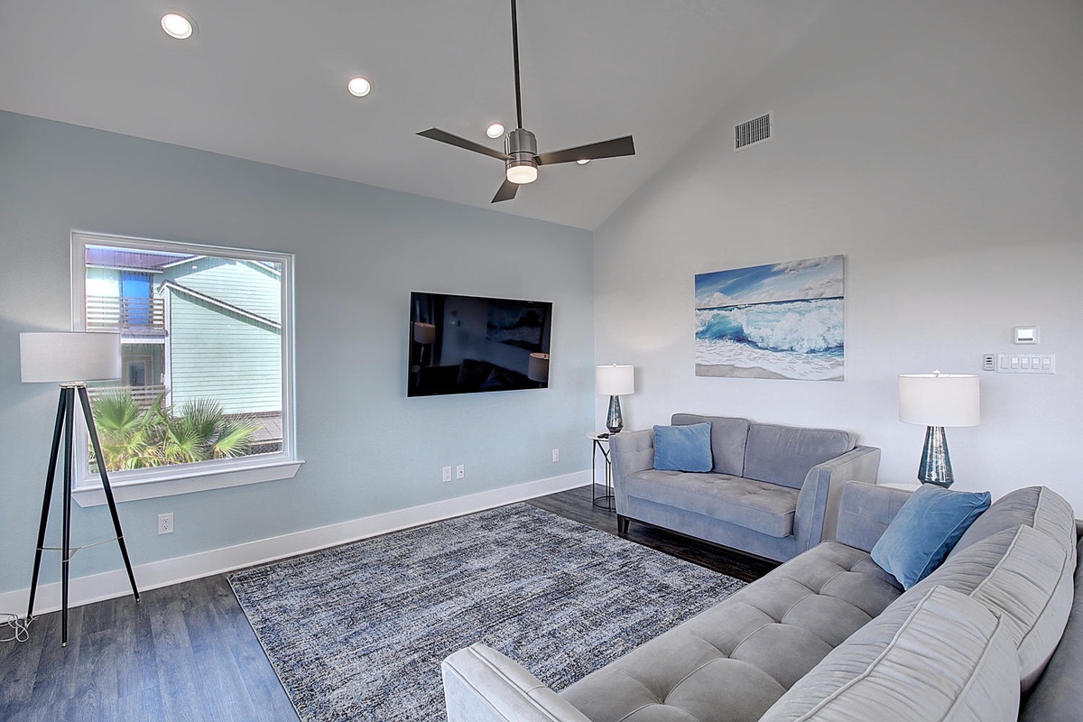 Unwind in your stylish living room with plush seating, modern lighting, and peaceful ocean artwork creating the perfect retreat.
