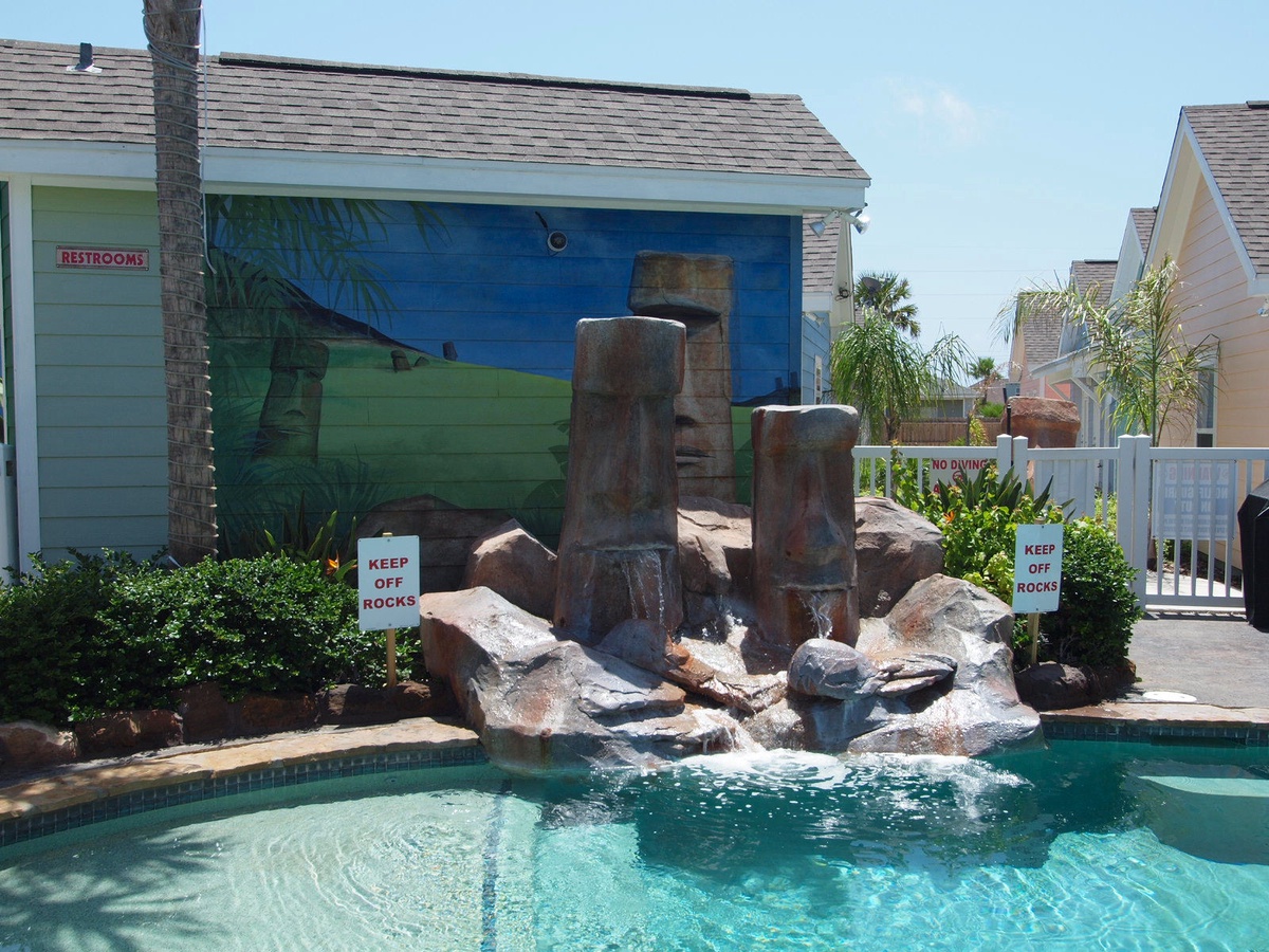 Splash into your own tropical paradise! Crystal-clear waters cascade over volcanic-inspired rock formations, creating your perfect poolside retreat.