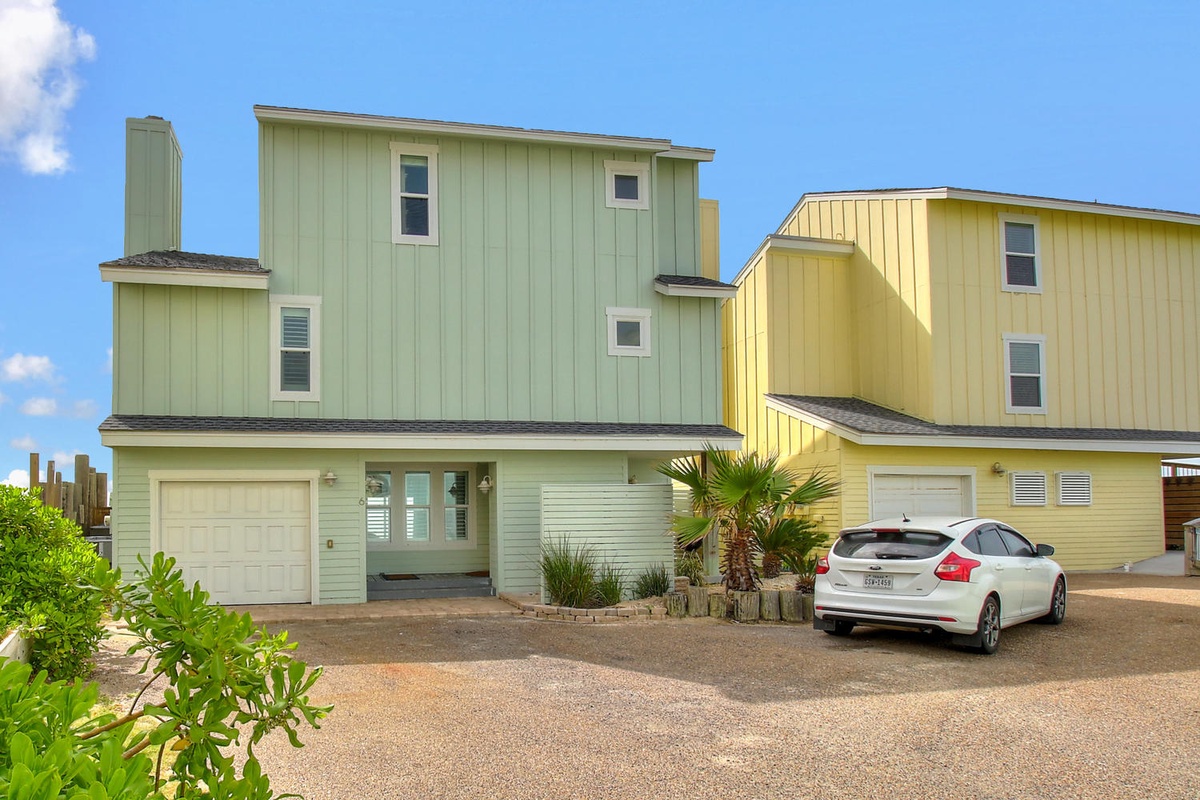 Colorful beachside properties with modern architecture and tropical landscaping in a coastal neighborhood setting.