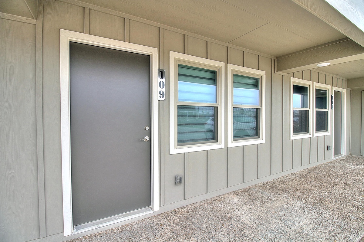 Modern property exterior featuring unit 109 with clean lines, neutral siding, and bright windows creating a welcoming arrival experience.