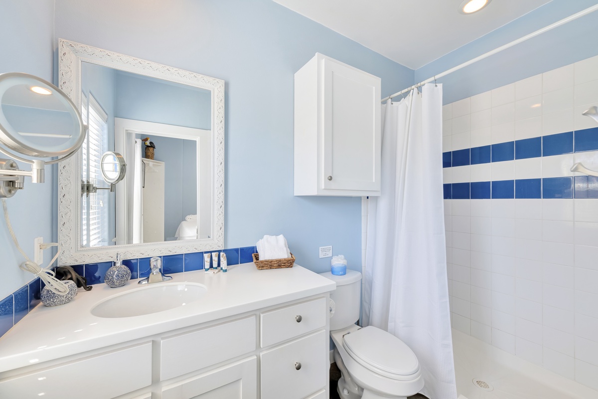 Your coastal-inspired bathroom features crisp white fixtures and soothing blue accents, creating a refreshing retreat for your morning routine.