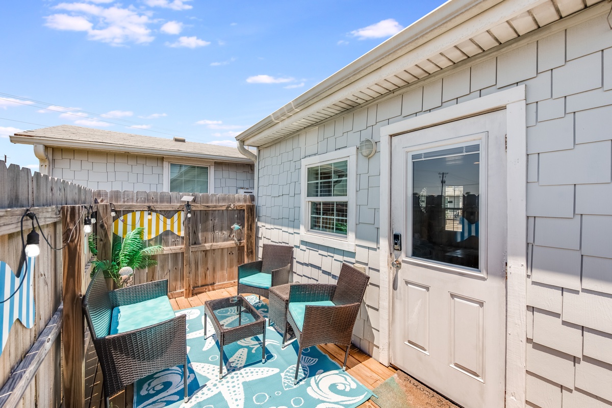 Soak up the sunshine on your private deck with comfy seating and coastal charm under beautiful blue skies.