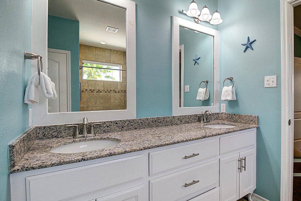 Start your day refreshed at your elegant double vanity with granite counters and ocean-themed touches.