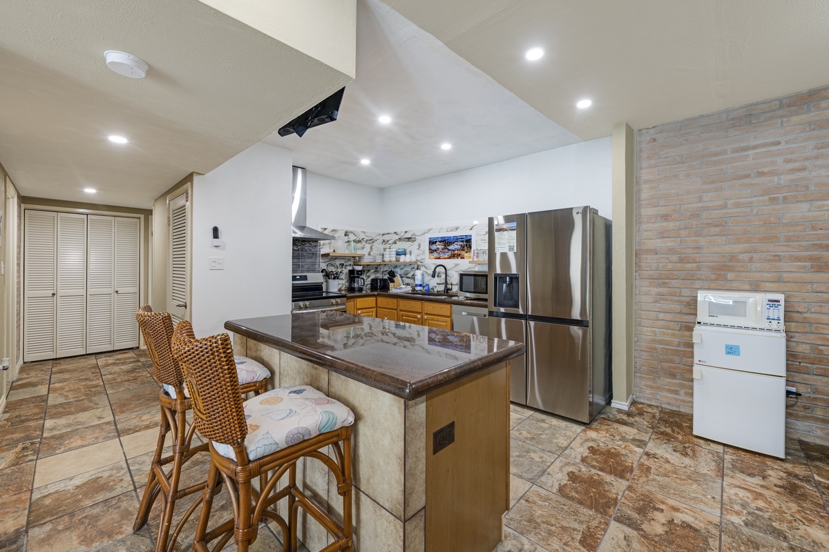 Your fully equipped kitchen features stainless steel appliances, granite countertops, and a convenient breakfast bar with seating—perfect for preparing meals and gathering with loved ones.