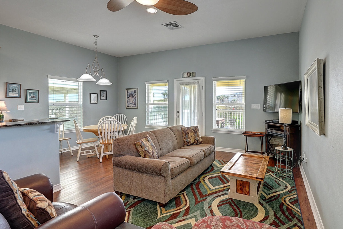 Relax in your bright, open living space with comfortable seating and warm wood floors. The ceiling fan keeps things cool while natural light flows in.
