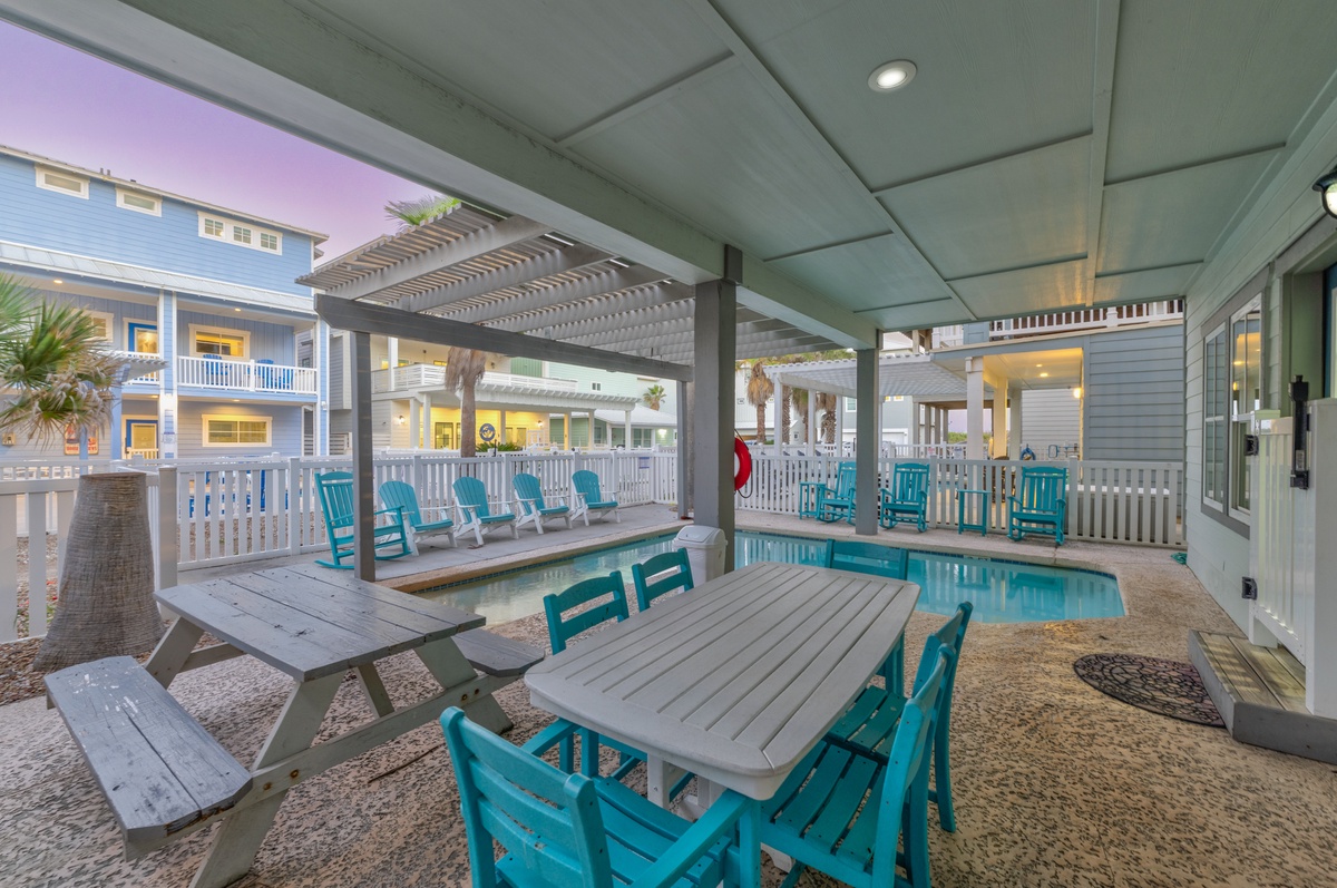 Relax in your private poolside paradise with colorful chairs and covered dining perfect for evening gatherings.
