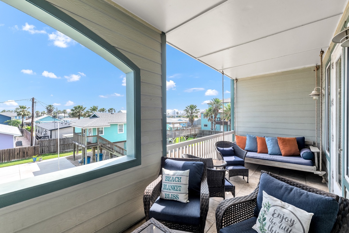 Your private covered balcony offers comfortable seating with coastal views, perfect for morning coffee or evening relaxation.
