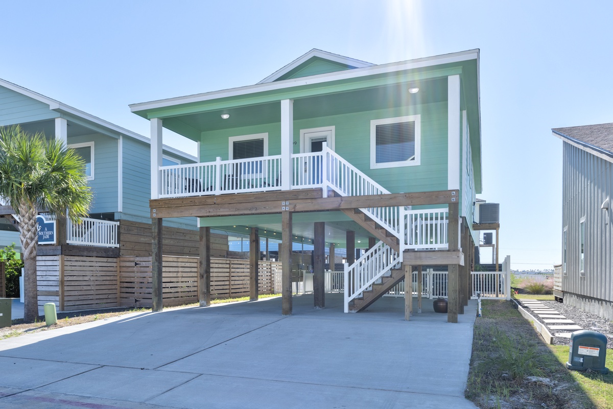 Charming coastal retreat featuring elevated design with covered parking and spacious balcony perfect for beach getaways.