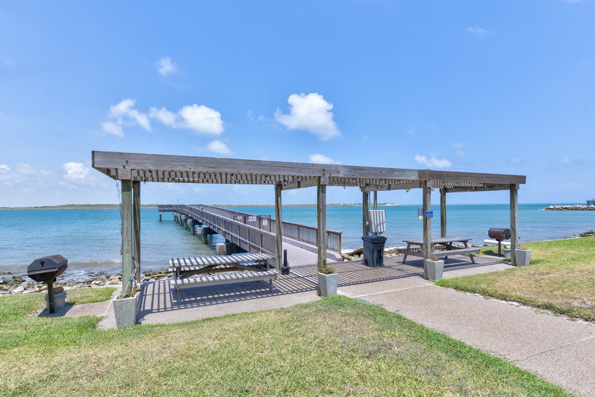 Scenic waterfront pier extends into turquoise waters, offering peaceful coastal views and recreational access in the surrounding area.