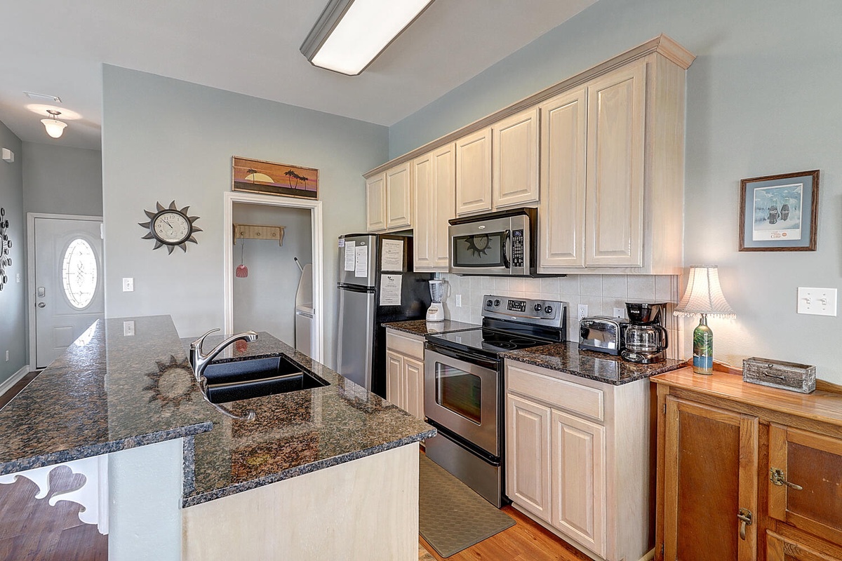 Your spacious kitchen features granite countertops, stainless steel appliances, and ample cabinet storage for preparing delicious meals during your stay.