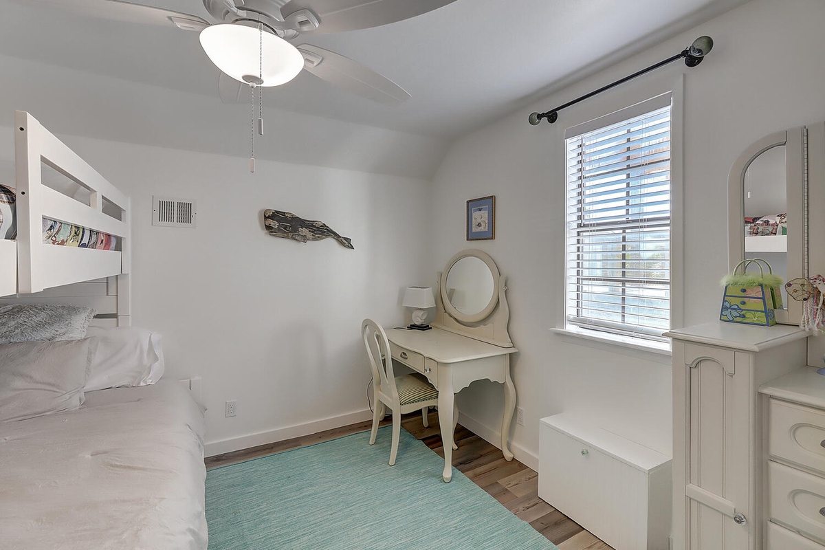 Your cozy bedroom features bunk beds, a charming vanity table, and plenty of natural light to start your mornings right.