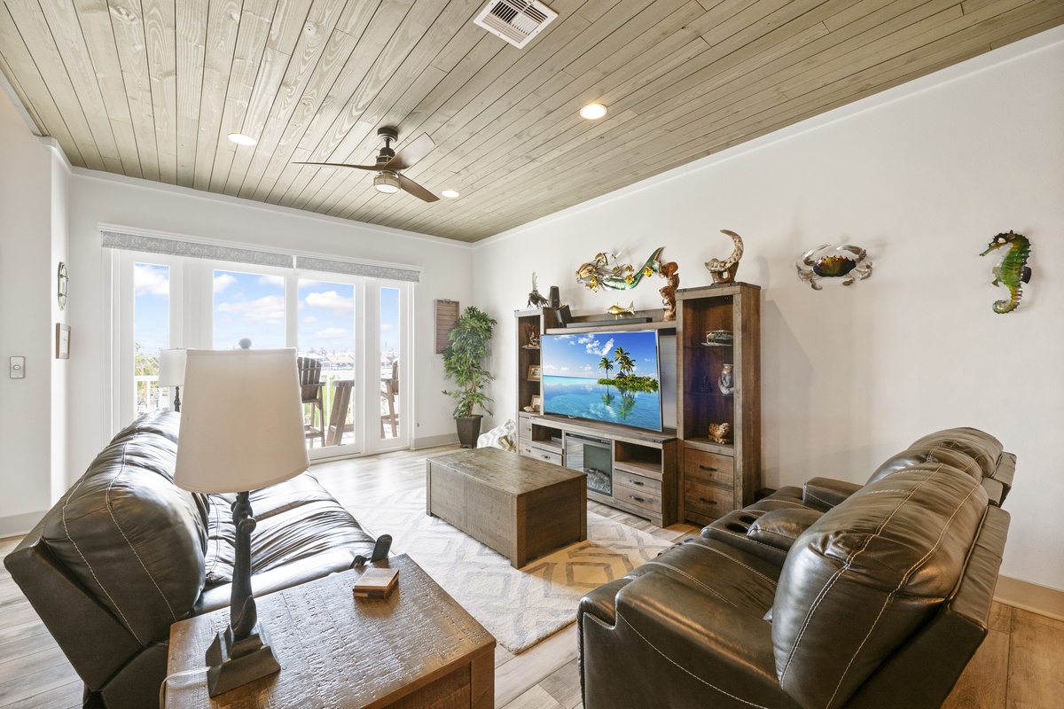 Unwind in this cozy living room with comfortable leather seating, coastal décor, and entertainment center perfect for movie nights.