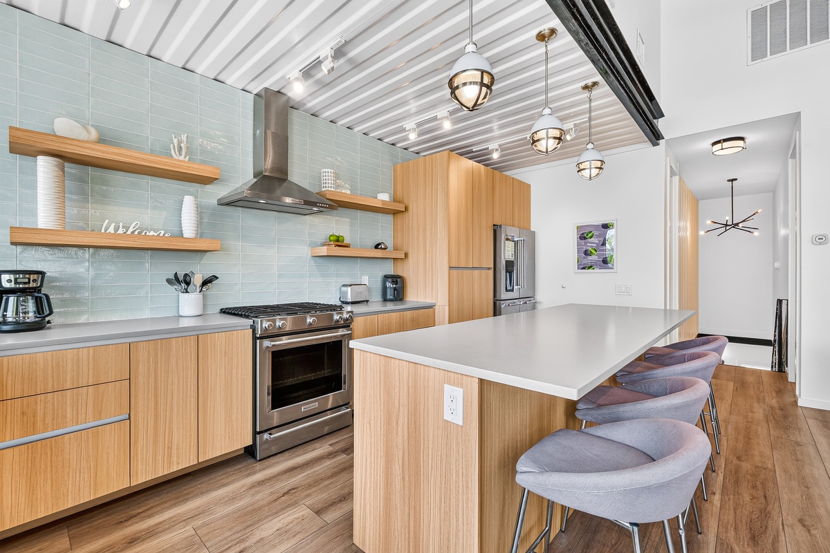 Step into your fully equipped modern kitchen, where sleek cabinetry, stainless steel appliances, and a spacious island invite you to whip up a feast or gather with loved ones over coffee and conversation.