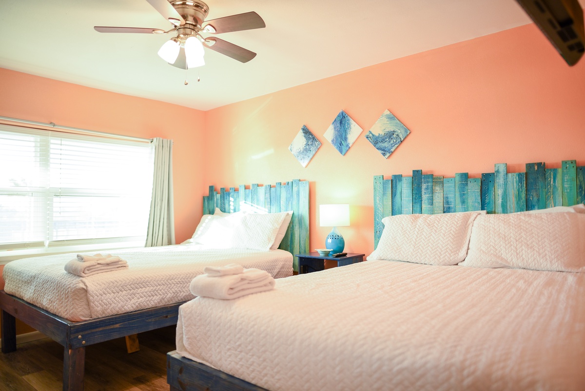 Rest peacefully in this bright bedroom with ocean-inspired decor, soft linens, and a gentle ceiling fan keeping you cool.