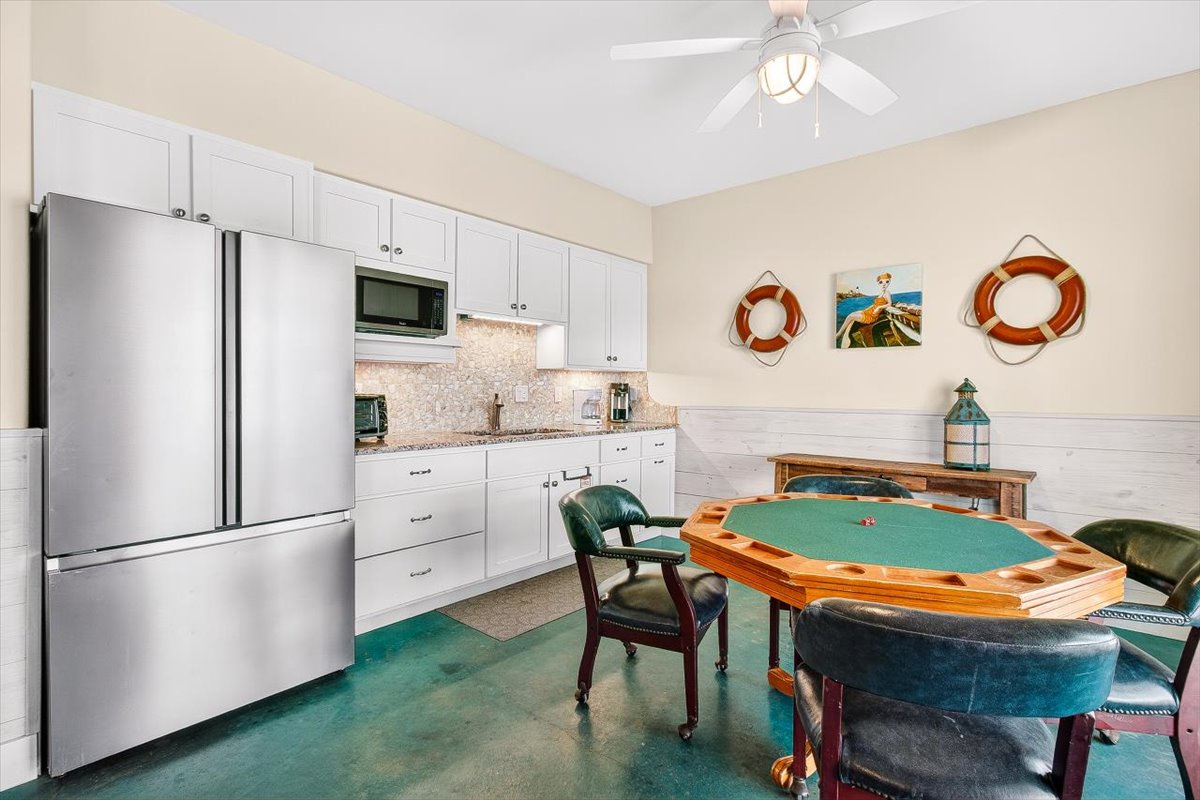 Your nautical-themed game room features a poker table and kitchenette, perfect for evening entertainment with coastal charm and life ring décor.