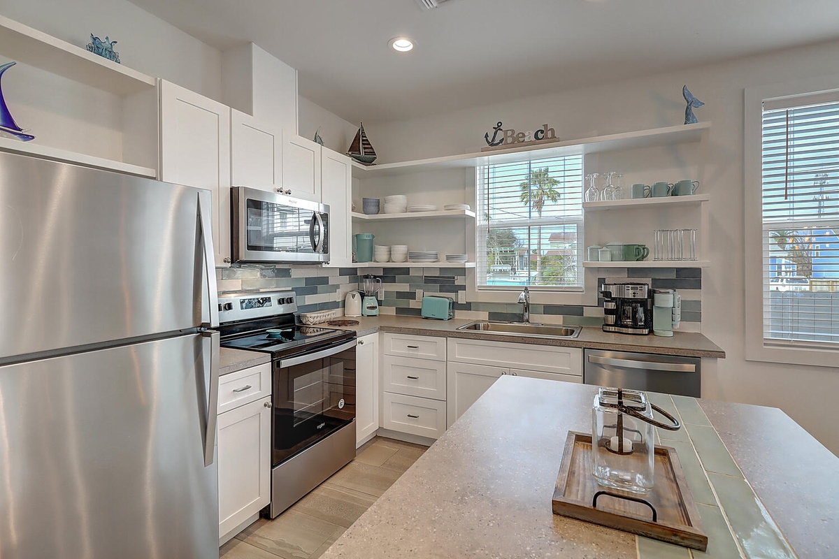 Your bright coastal kitchen awaits with modern appliances, granite counters, and charming nautical touches that make cooking a joy.