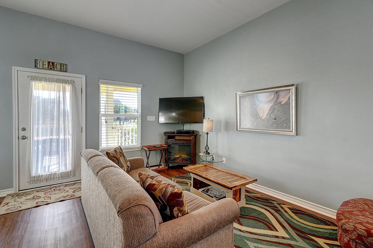 Unwind in your cozy living room with comfortable seating, warm fireplace, and entertainment center for perfect relaxation after your beach adventures.
