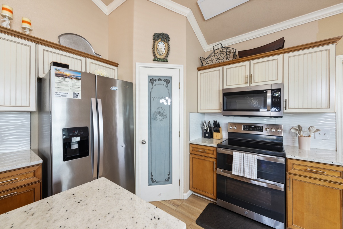 Cook your favorite meals in the spacious kitchen featuring stainless steel appliances, abundant cabinetry, and everything needed for your stay.