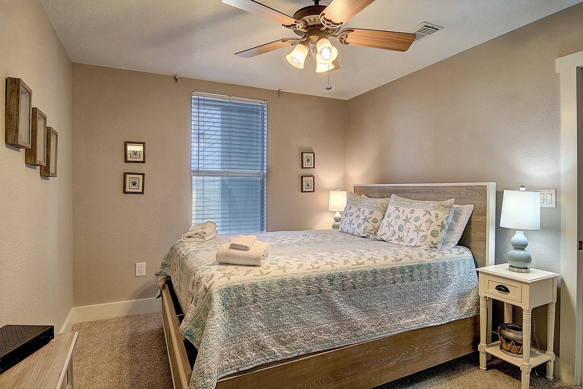 Sink into this cozy bedroom with soft linens and gentle ceiling fan breeze keeping you comfortable all night.