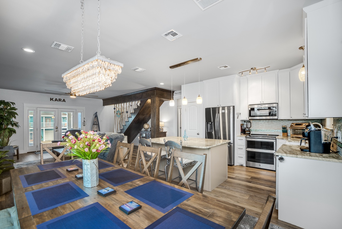 Gather with loved ones in this stunning open-concept space where elegant chandeliers illuminate your culinary adventures and cozy conversations flow effortlessly.