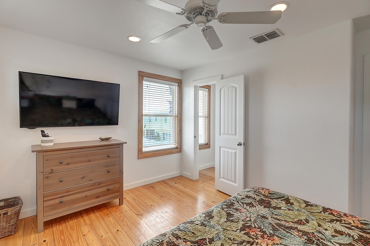 Wake up refreshed in your bright bedroom with hardwood floors, ceiling fan, and flat-screen TV for cozy evening entertainment.
