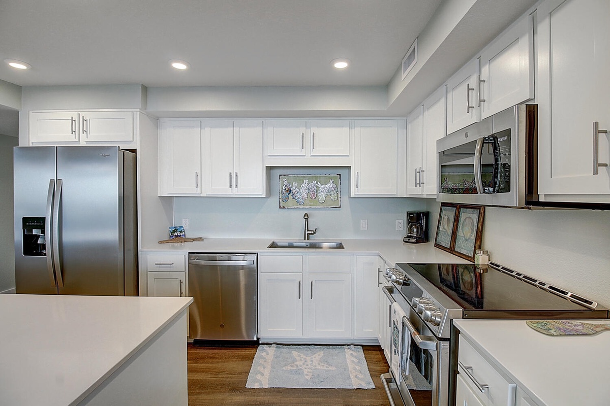 Your fully equipped kitchen features sleek white cabinets, stainless steel appliances, and everything you need to create memorable meals during your stay.