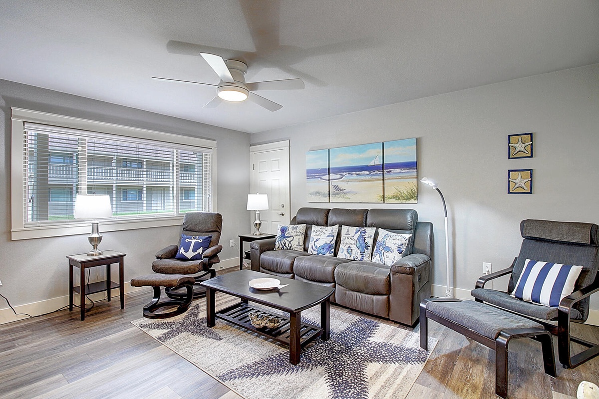Unwind in your stylish living room where coastal artwork and nautical touches create a peaceful retreat. Sink into the leather sofa and enjoy the gentle breeze from the ceiling fan.