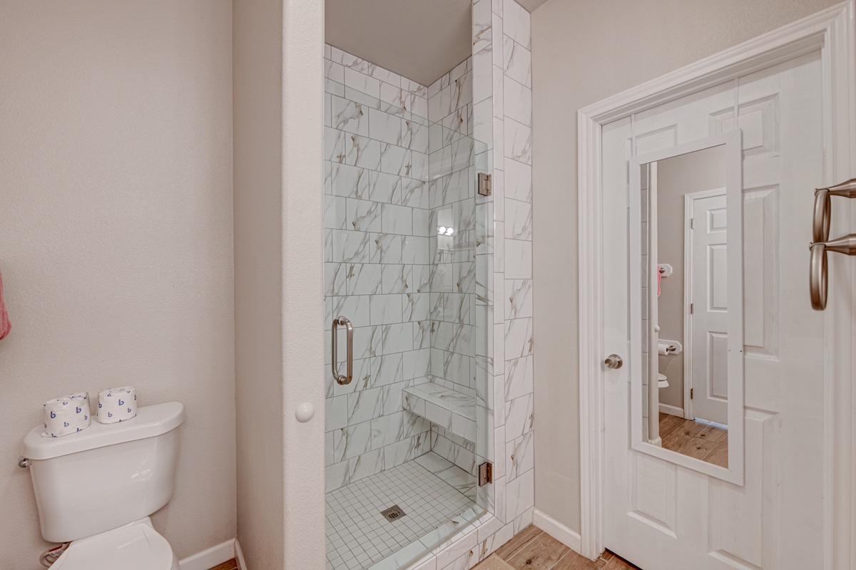 Step into your elegant marble-tiled shower, where stunning veining creates a luxurious spa-like retreat for your daily refresh.