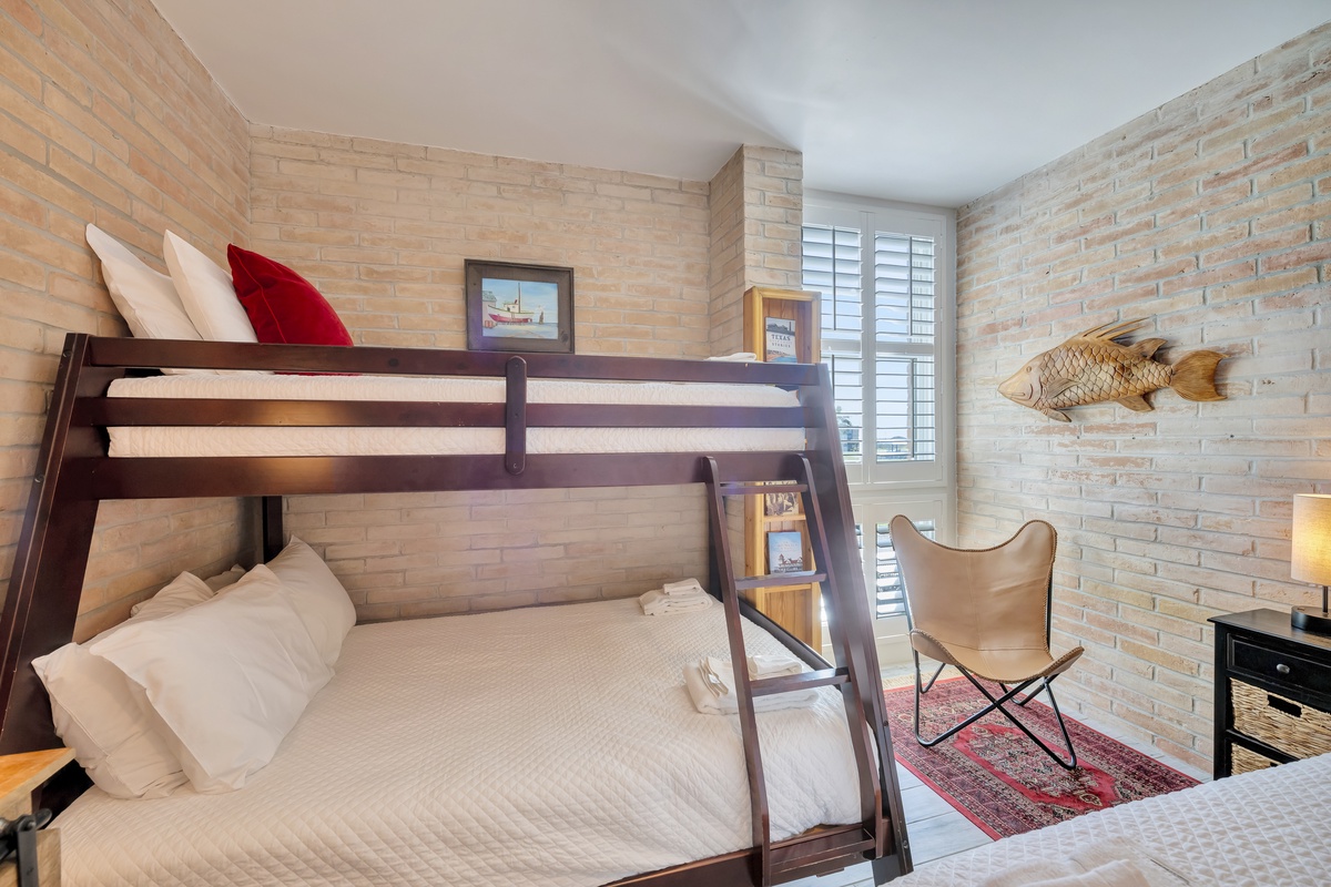 Your cozy bunk room features exposed brick walls and stylish furnishings, perfect for families or groups sharing memorable moments together.