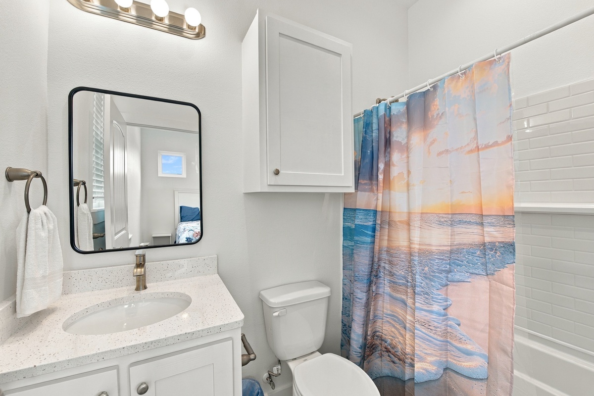 Step into your private, freshly styled bathroom with a walk in shower, where crisp white subway tile and coastal touches welcome you.