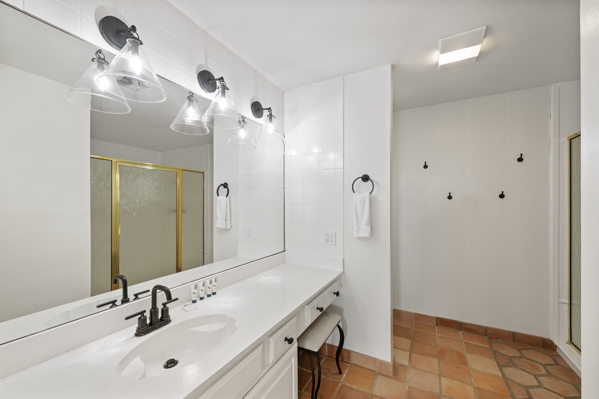 Freshen up in your spacious bathroom with bright vanity lighting and stylish terra cotta flooring for your comfort.