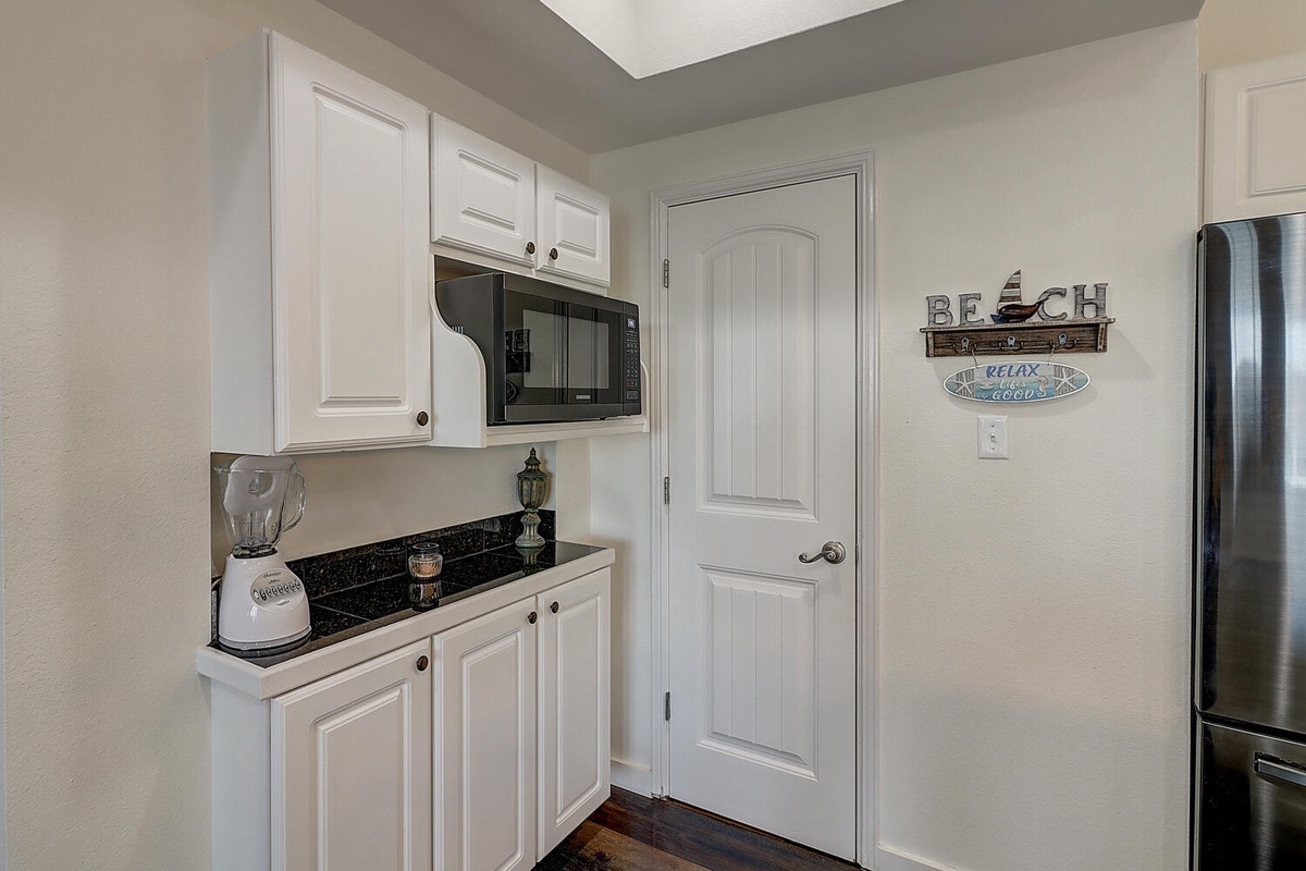 Your bright kitchenette features modern appliances and beach-themed touches, perfect for preparing quick meals during your coastal getaway.