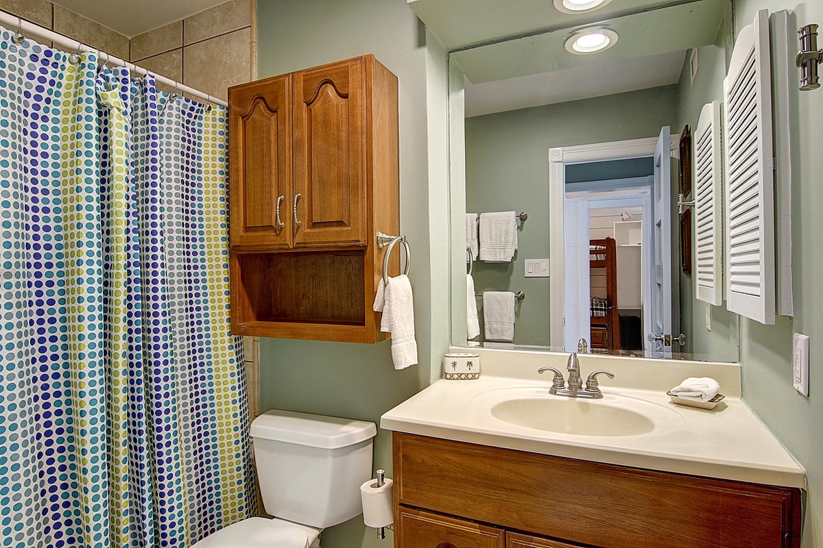 Step into your private bathroom featuring a refreshing shower, elegant vanity, and charming wooden cabinetry that adds warmth to your daily routine.