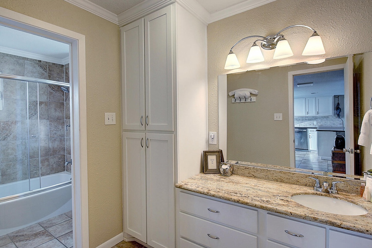 Start your day in this elegant bathroom with granite counters, ample storage, and beautiful vanity lighting creating the perfect morning routine.