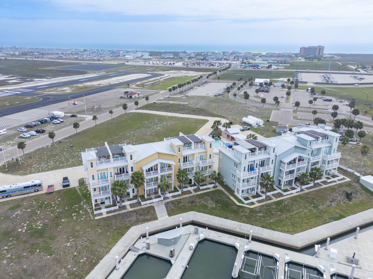 Modern beachside condos positioned near marina docks and coastal airport, offering convenient access to both waterfront activities and travel connections.