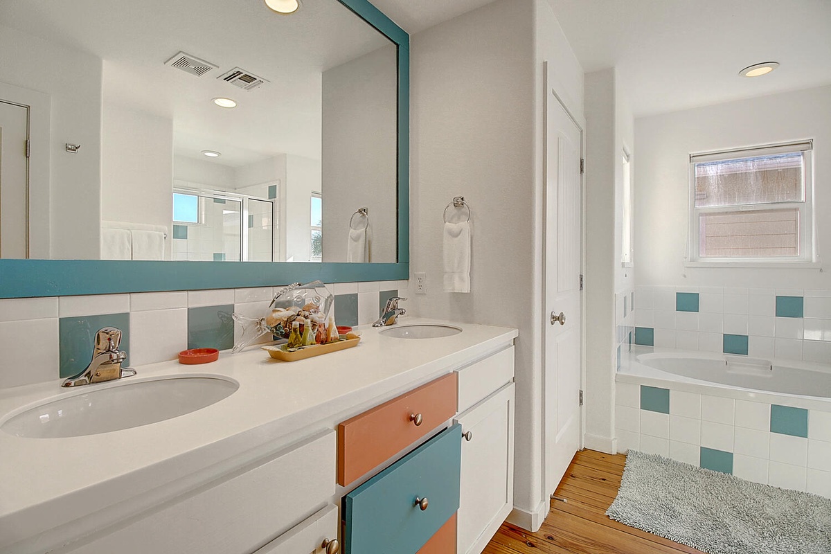 Step into your stylish bathroom featuring dual sinks, colorful accents, and a relaxing tub-shower combo perfect for unwinding after your adventures.