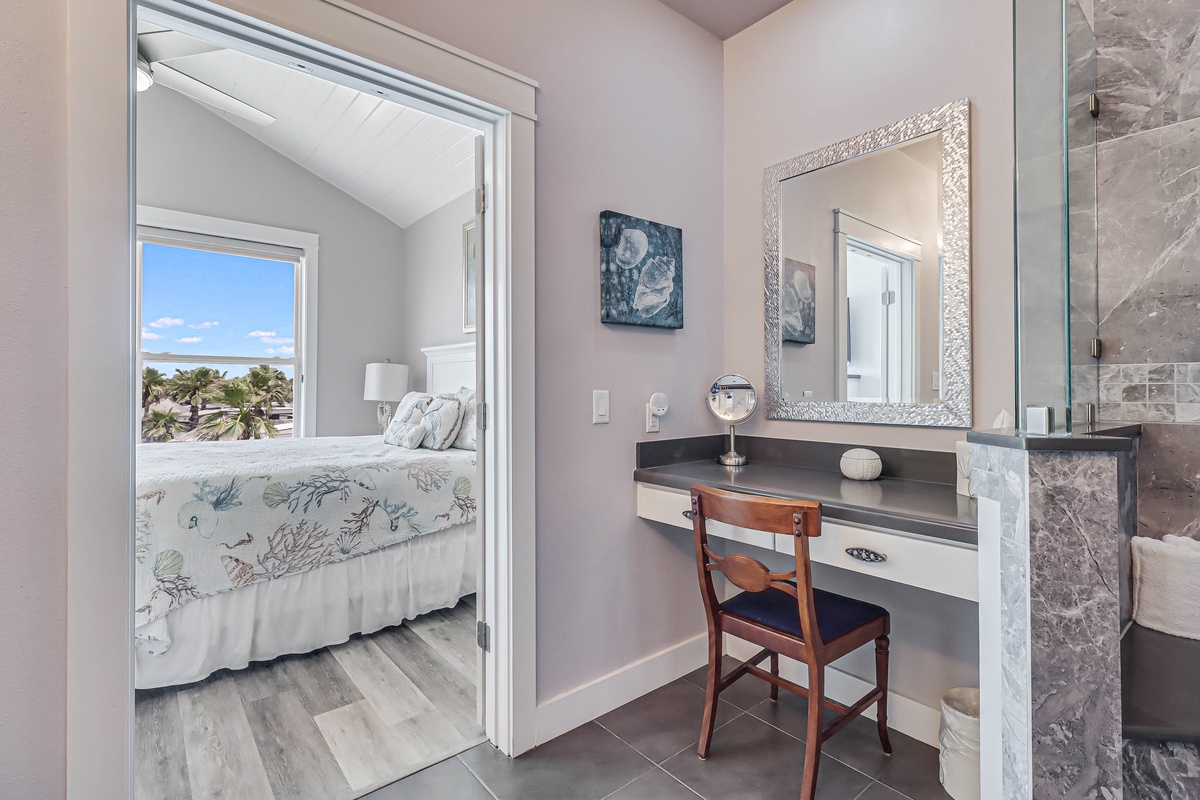 Your elegant vanity area awaits, complete with a stylish mirror and convenient workspace, perfectly connected to your comfortable bedroom.