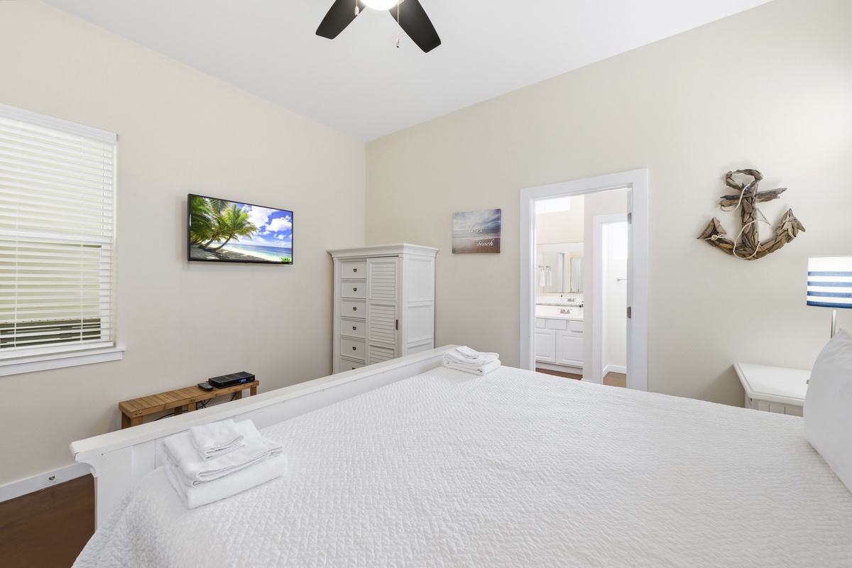 Sink into your plush bed and enjoy the coastal decor, ceiling fan, and flat-screen TV—your private retreat with an ensuite bath.