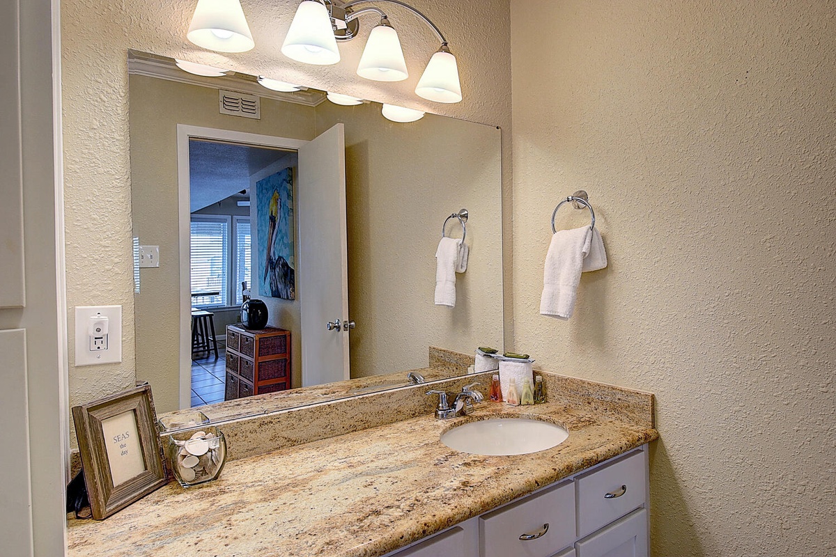 Your bright bathroom vanity offers granite countertops and warm lighting for your morning routine.