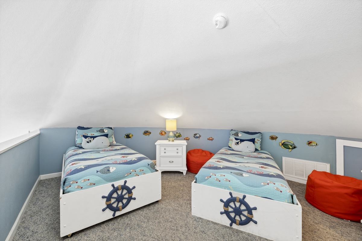 Your kids will love this nautical-themed twin bedroom with whale bedding and ocean wall decals creating magical underwater dreams.